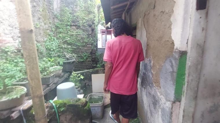 Janim saat menunjukan tempat bersih-bersih di gang dekat rumahnya untuk mandi malam (Foto: TitikNOL)