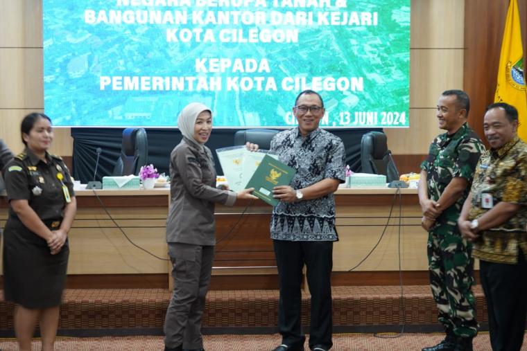 Kepala Kejari Kota Cilegon, Diana Wahyu Widiyanti menyerahkan secara simbolis aset tanah dan bangunan kepada Walikota Cilegon, Helldy Agustian. (Foto: TitikNOL)