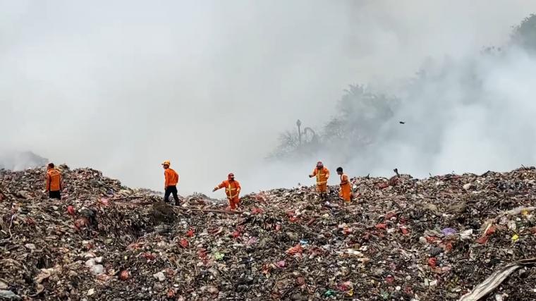 Petugas saat memadamkan api di TPSA Bagendung yang terbakar. (Foto: TitikNOL)
