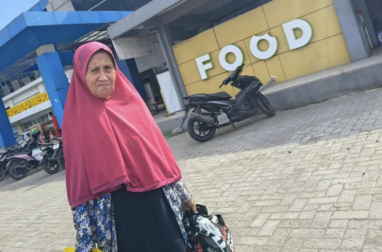 Rohanah (70) nenek yang bejalan kaki karena skema jalur pejalan kaki yang diberlaku di Pelabuhan Merak, Banten pada momen perjalanan Natal dan Tahun baru. (Foto: TitikNOL)