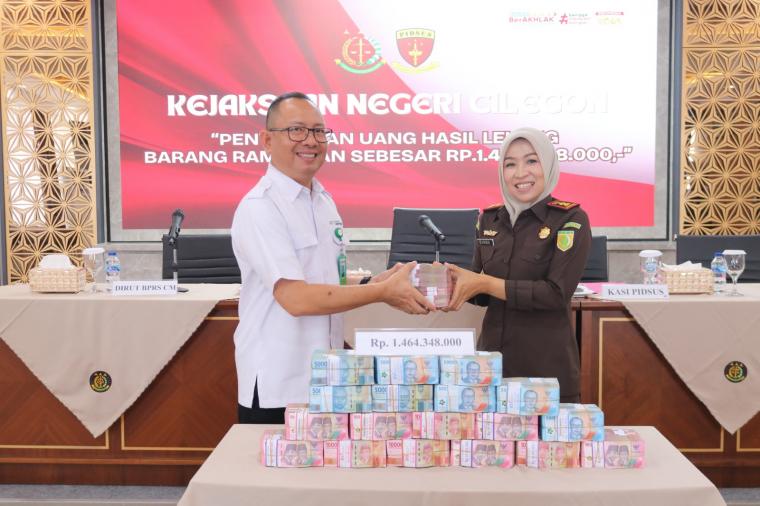 Kepala Kejari Kota Cilegon Diana Wahyu Widiyanti saat menyerahkan uang hasil korupsi ke Direktur Utama BPRS - CM Novran Erviatman Syarifudin. (Foto: Istimewa)