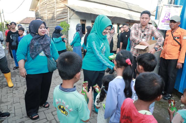 Ketua TP PKK Kota Serang Arfina Rustandi saat berbagi makanan dengan anak anak korban banjir.